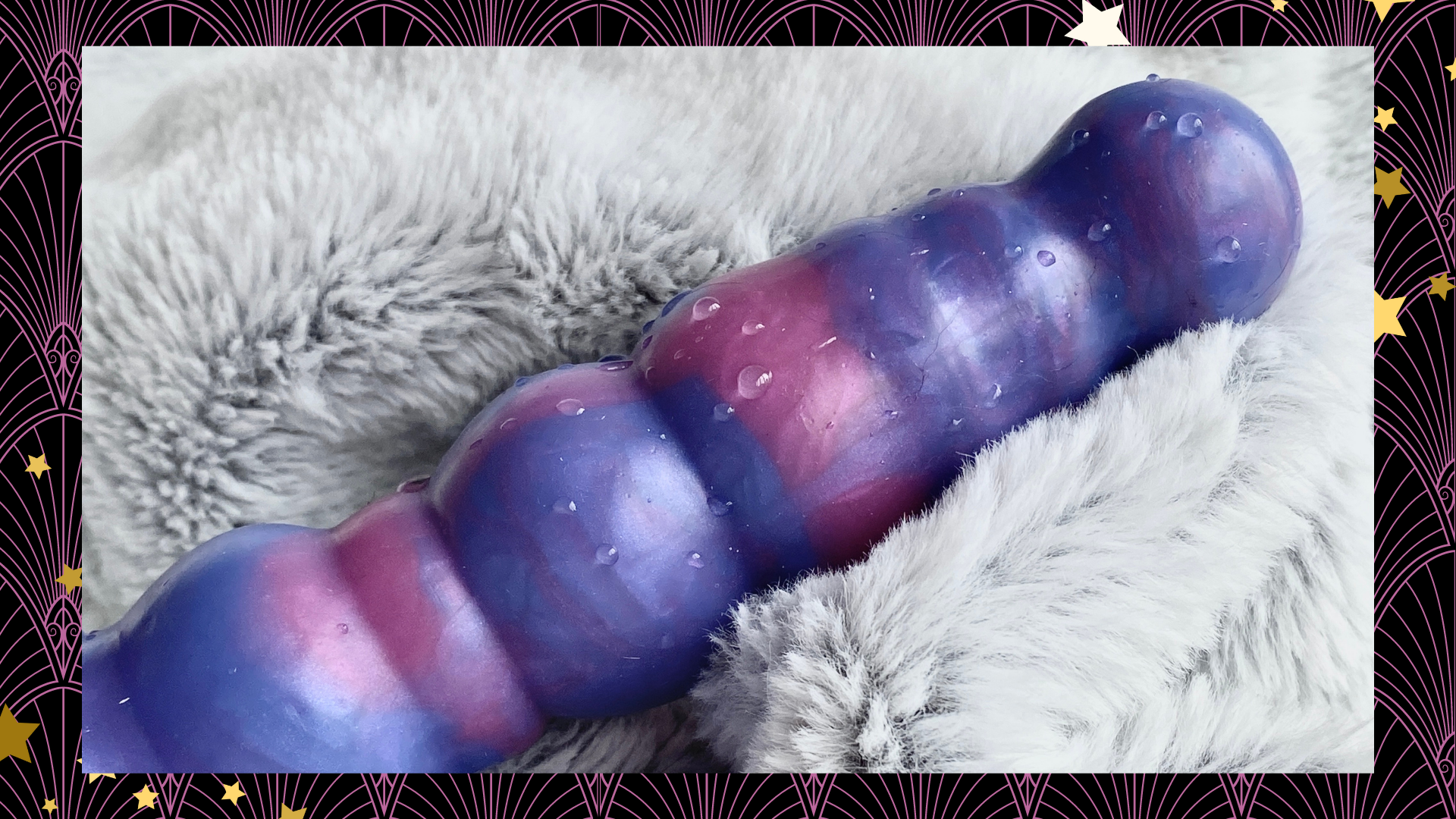 a pink and purple dildo nestled in a silver-grey fur