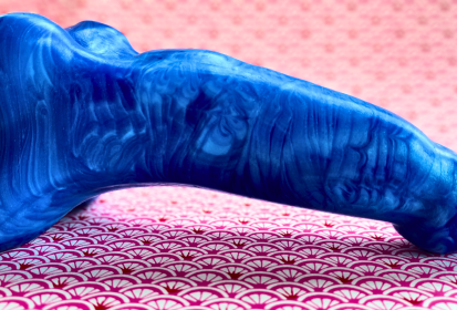 blue tidebloom dildo from Element Pleasures, on a pink patterned background